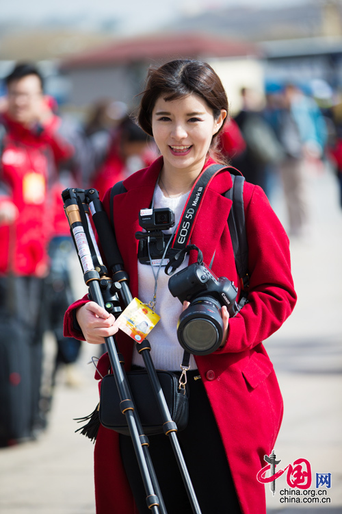 2016年兩會，人民大會大堂前，一位笑容燦爛的紅衣女記者正步入大會堂。中國網(wǎng) 鄭亮 攝