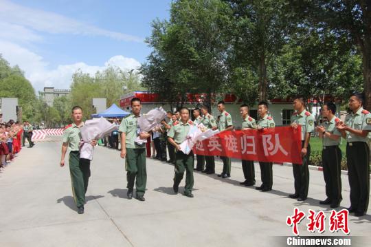 部隊官兵們迎接出院歸來的李運飛(中)和其他消防戰(zhàn)士?！⊥粲?攝