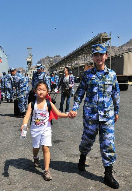 2015年3月，也門，海軍女戰(zhàn)士牽著一名小女孩的手準備登上軍艦。